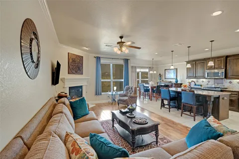 a living room with furniture kitchen view and a chandelier