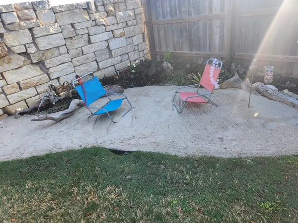 a view of a backyard with plants and outdoor seating