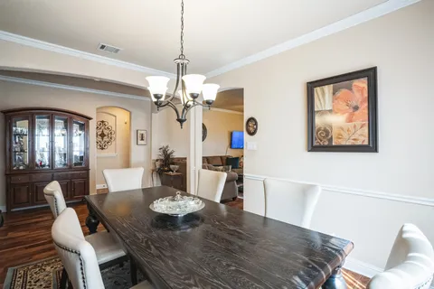 a view of a dining room with furniture a chandelier and wooden floor
