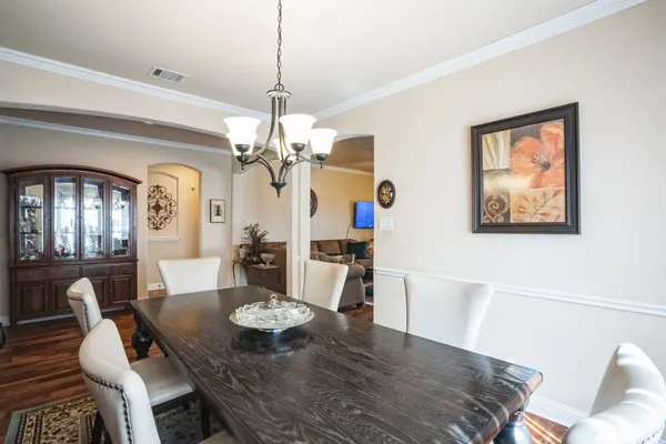 a view of a dining room with furniture a chandelier and wooden floor