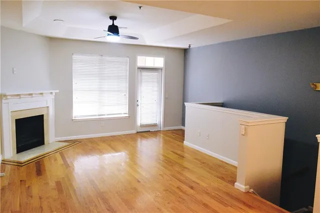 a view of empty room with wooden floor and fireplace