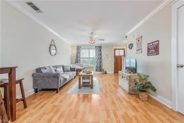 a living room with furniture and a wooden floor