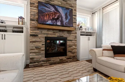a living room with furniture a flat screen tv and a fireplace