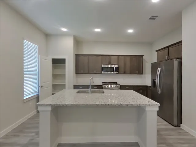 a kitchen with stainless steel appliances a refrigerator sink microwave and stove