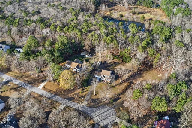 a aerial view of residential house with outdoor space and trees all around