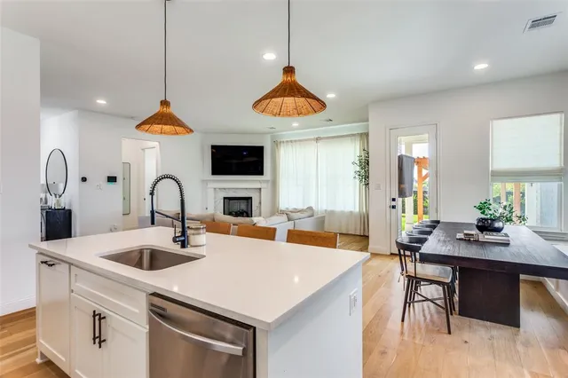a kitchen with stainless steel appliances granite countertop a sink a stove and a wooden floor
