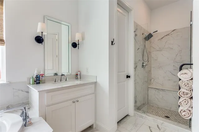 a bathroom with a sink vanity granite shower and a mirror