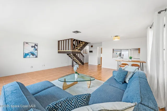 a living room with furniture and a floor to ceiling window