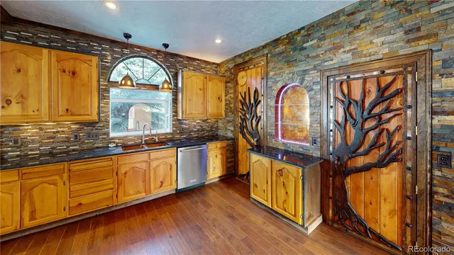 a view of a kitchen with wooden floor and stainless steel appliances