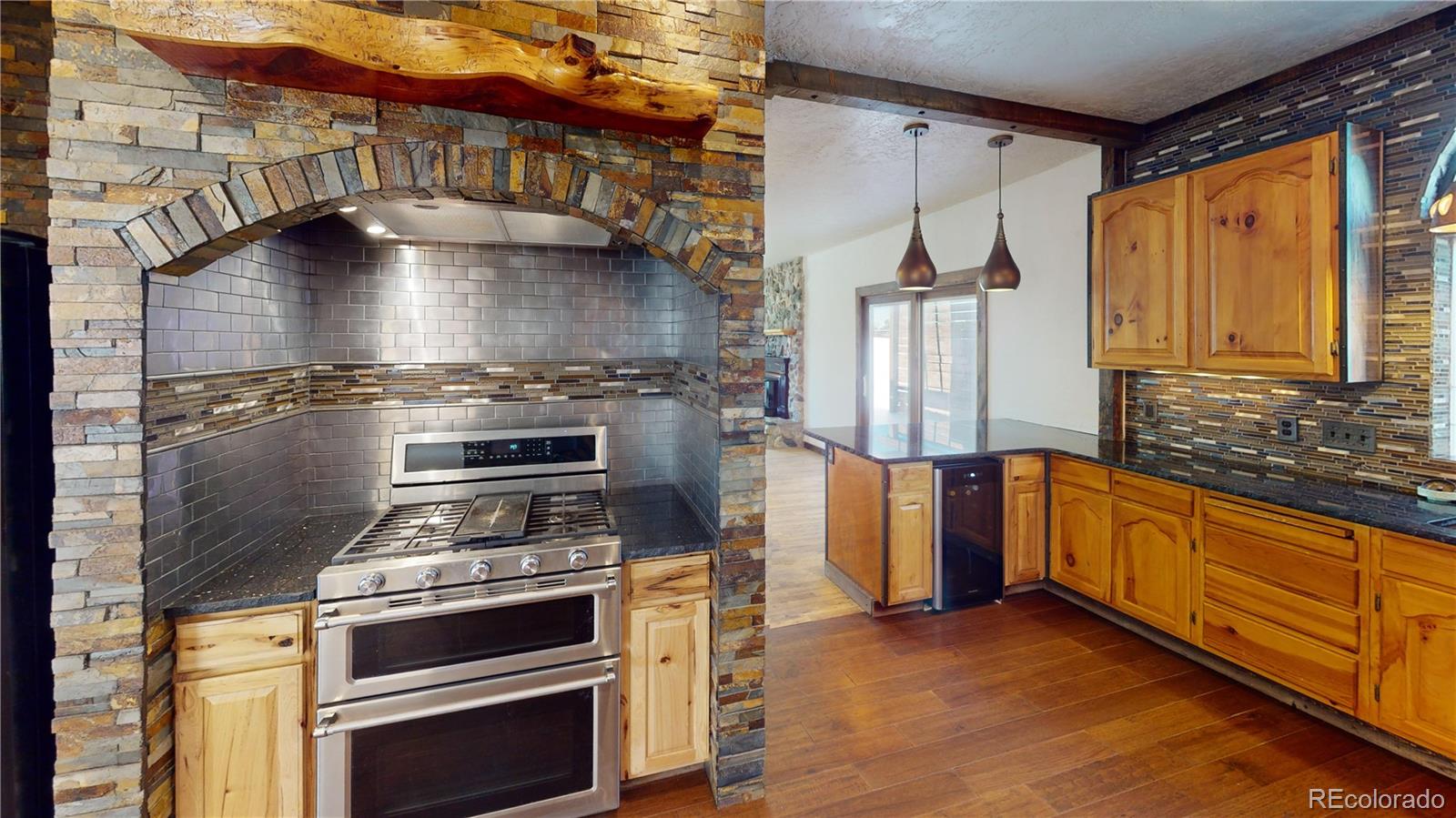 309 Main Street Romeo, CO 81148 - Photo 14 of 41 a kitchen with granite countertop a stove and a refrigerator