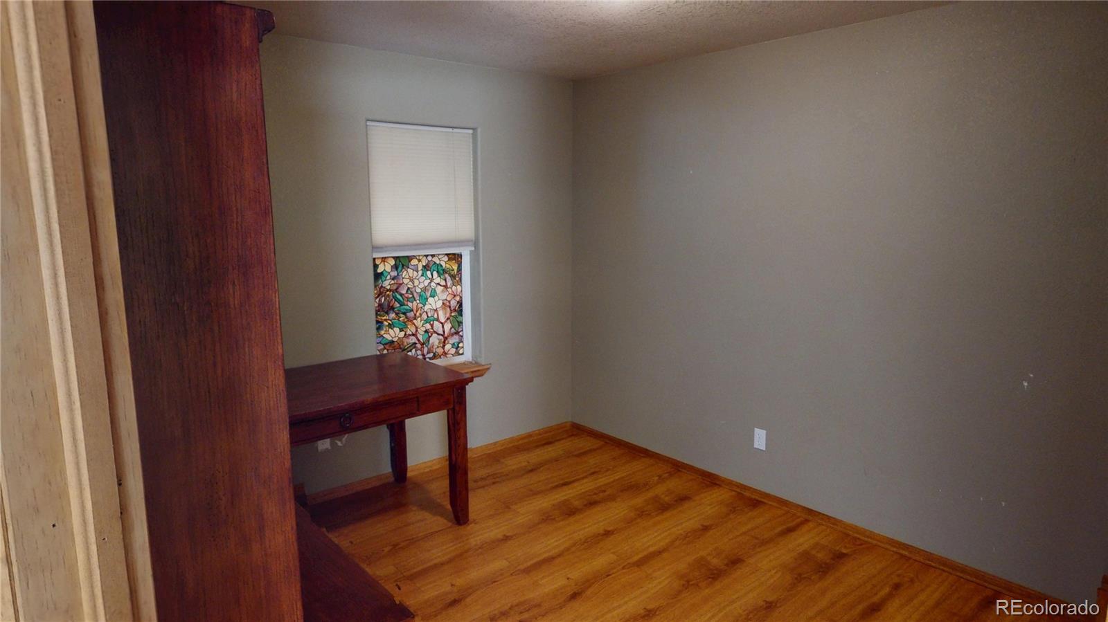 309 Main Street Romeo, CO 81148 - Photo 24 of 41 a workspace room with wooden floor and furniture