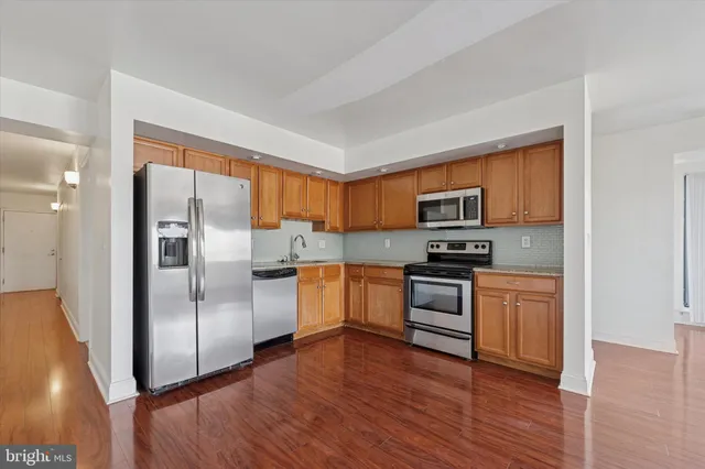 a kitchen with granite countertop stainless steel appliances and wooden cabinets