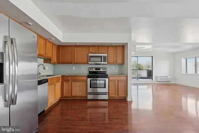 a kitchen with granite countertop a refrigerator stove top oven and sink