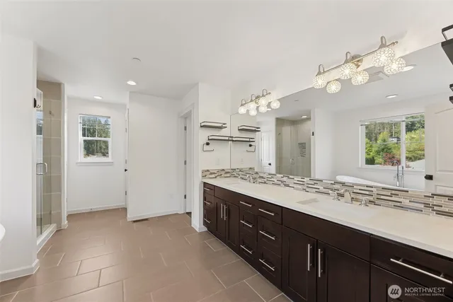 a bathroom with a granite countertop double vanity sink and a mirror