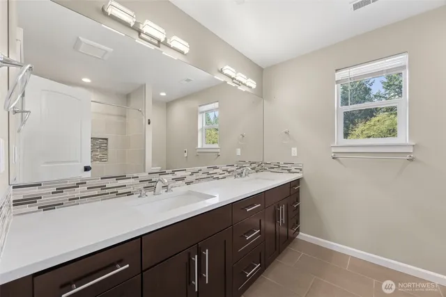 a bathroom with a sink double vanity and a mirror