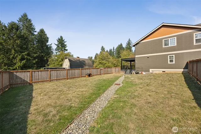 a view of a house with a yard and large tree