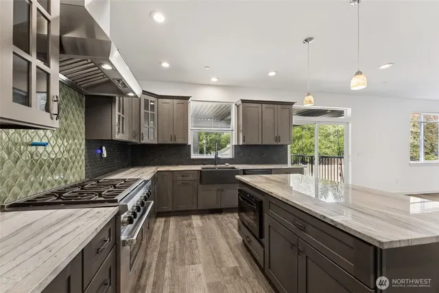 a kitchen with stainless steel appliances granite countertop sink stove and cabinets