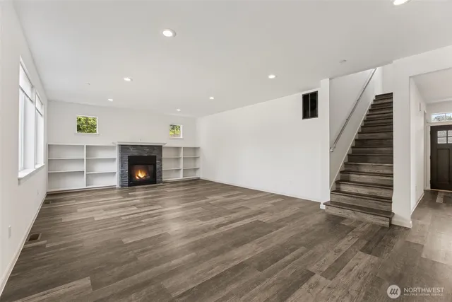 an empty room with wooden floor and fireplace