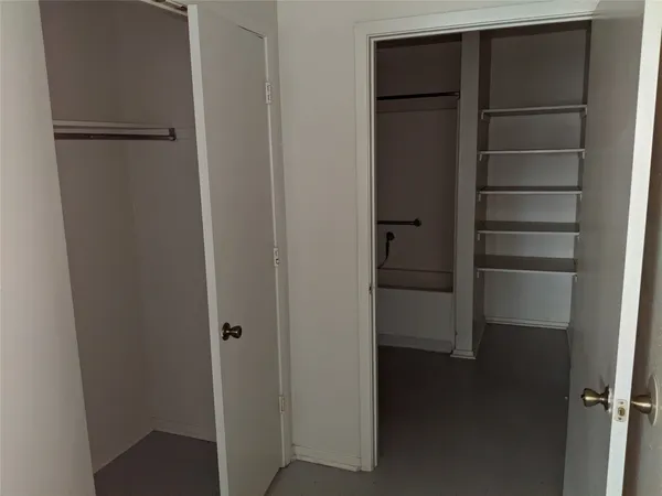 a view of walk in closet with empty racks
