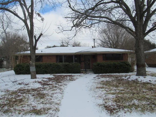 a front view of a house with a yard covered in snow