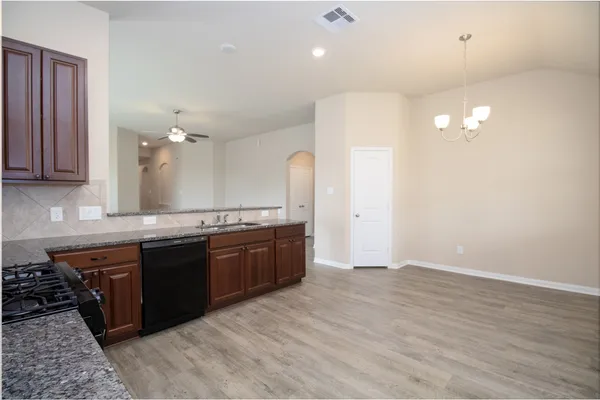 a large kitchen with granite countertop a stove a sink a refrigerator and a granite counter tops