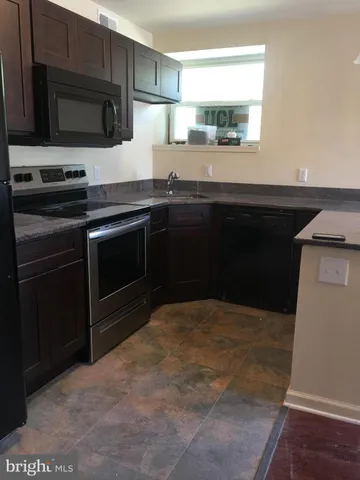 a kitchen with granite countertop a sink and a stove top oven
