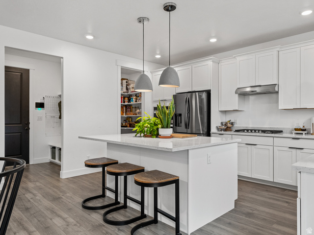 627 South Meade Street Mapleton, UT 84664 - Photo 8 of 37 Modern kitchen featuring a central island with countertop seating, white shaker cabinetry, stainless steel appliances, and wood-finish flooring