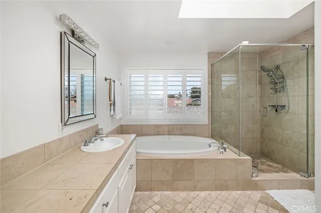 a bathroom with a granite countertop tub sink shower and mirror