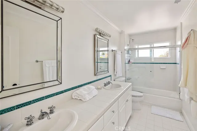 a bathroom with a double vanity sink mirror and shower