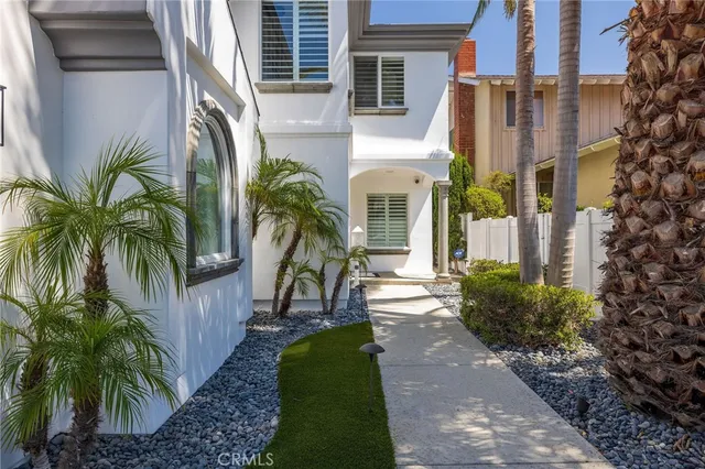 a view of a tall building with a yard and potted plants