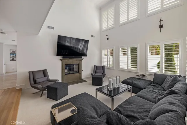 a living room with furniture a flat screen tv and a large window