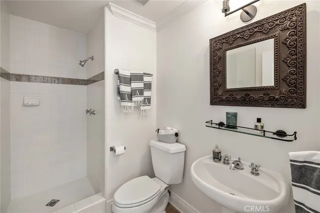 a bathroom with a toilet sink a shower and a mirror