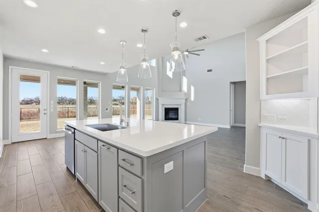 a large white kitchen with a large window a oven and stainless steel appliances