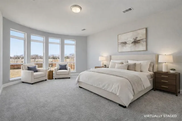 a spacious bedroom with a bed and large window