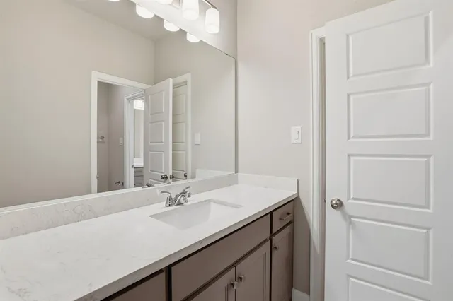 a bathroom with a sink vanity and a mirror