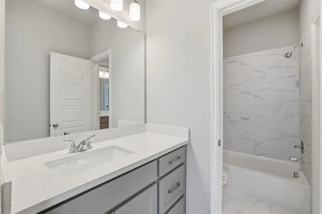 a bathroom with a sink a tub and a mirror