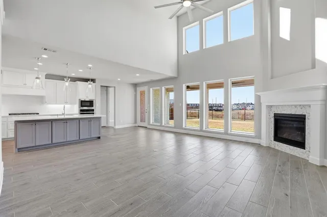 a view of an empty room with kitchen and a window