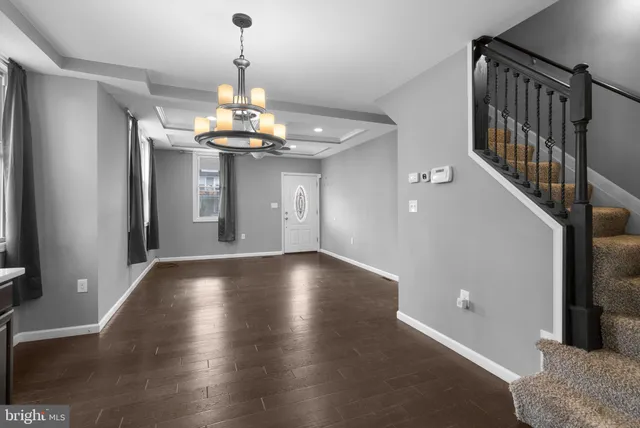 a view of an empty room with wooden floor and cabinets