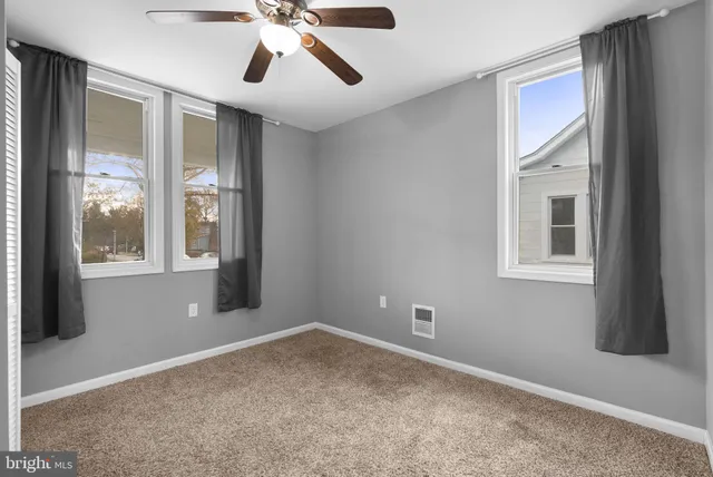 a view of a livingroom with a ceiling fan and window