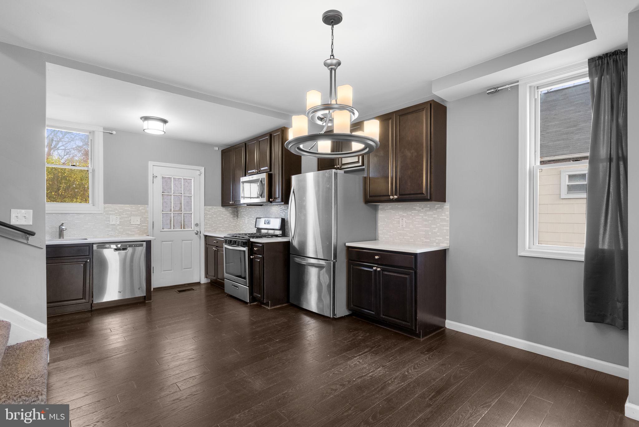 4308 Mainfield Avenue Baltimore, MD 21214 - Photo 10 of 41 a kitchen with stainless steel appliances granite countertop a stove a sink dishwasher a refrigerator and a wooden floor
