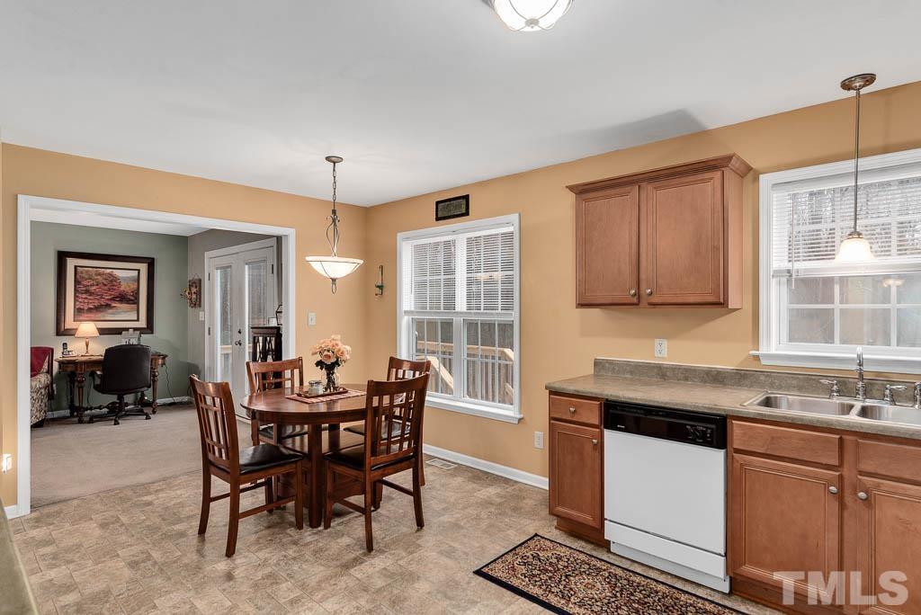 201 Tast Drive Wendell, NC 27591 - Photo 8 of 22 a kitchen with granite countertop dining table chairs cabinets and stainless steel appliances