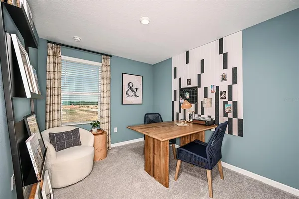 a bedroom with a bed a mirror with lamp and a large window