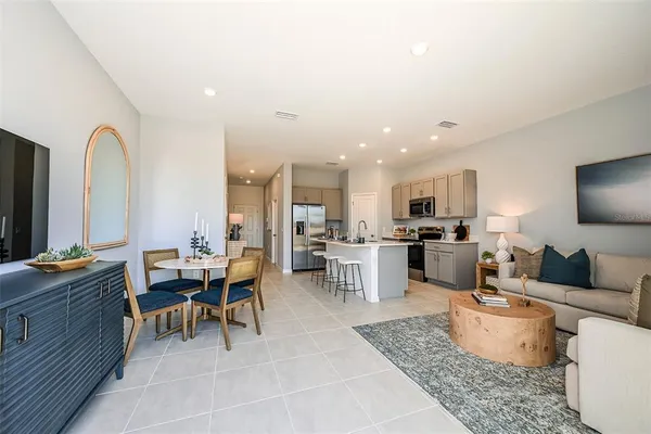 a living room with furniture a rug and kitchen view