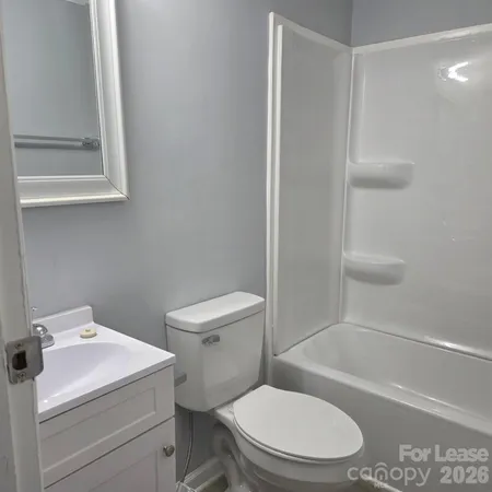 a white toilet sitting next to a bath tub
