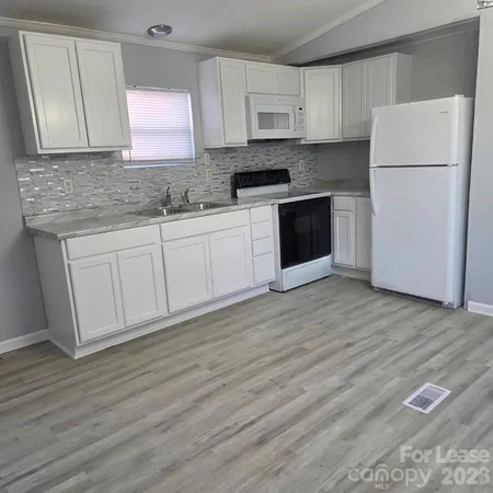 a kitchen with a refrigerator sink and cabinets