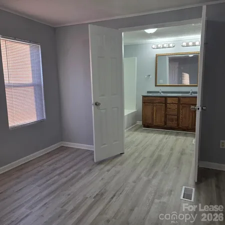 an empty room with wooden floor and mirror