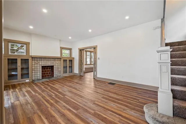 a view of empty room with wooden floor and fireplace