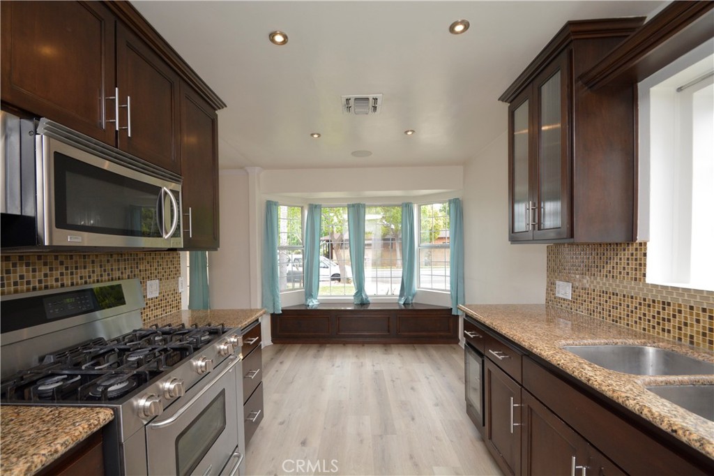 12301 Rives Avenue Downey, CA 90242 - Photo 4 of 20 a kitchen with a stove a sink and a microwave
