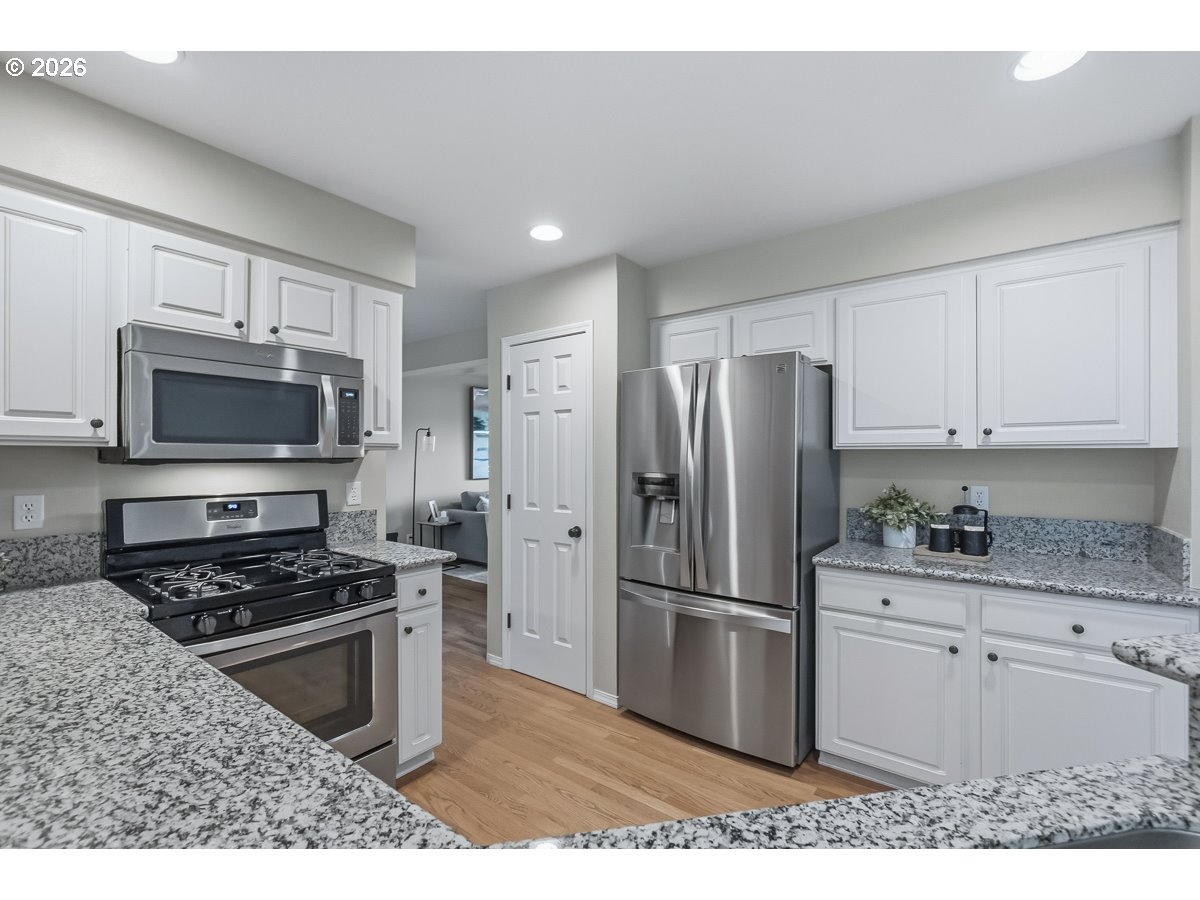 8361 Southwest 168th Avenue Beaverton, OR 97007 - Photo 12 of 31 a kitchen with stainless steel appliances granite countertop a refrigerator stove and microwave