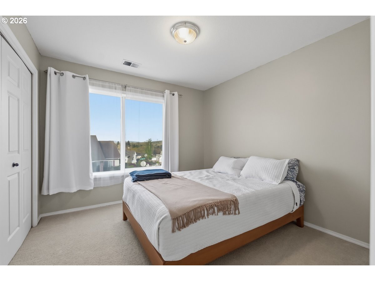 8361 Southwest 168th Avenue Beaverton, OR 97007 - Photo 17 of 31 a bedroom with a bed and a large window